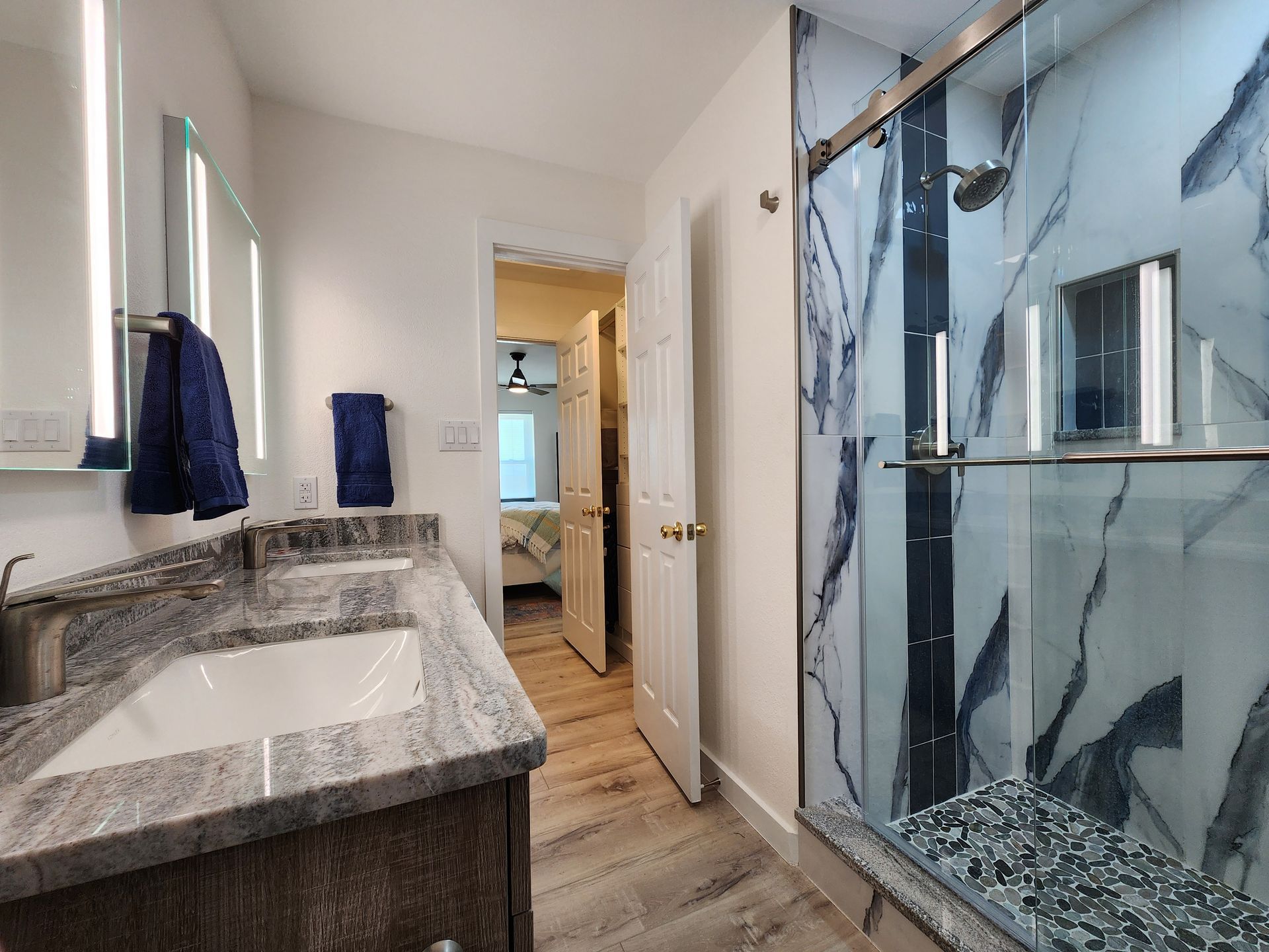 A bathroom with two sinks and a walk in shower.