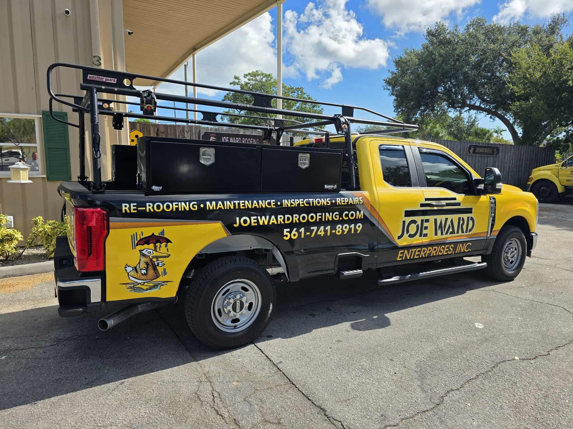 Yellow service truck with black toolboxes, rack. 