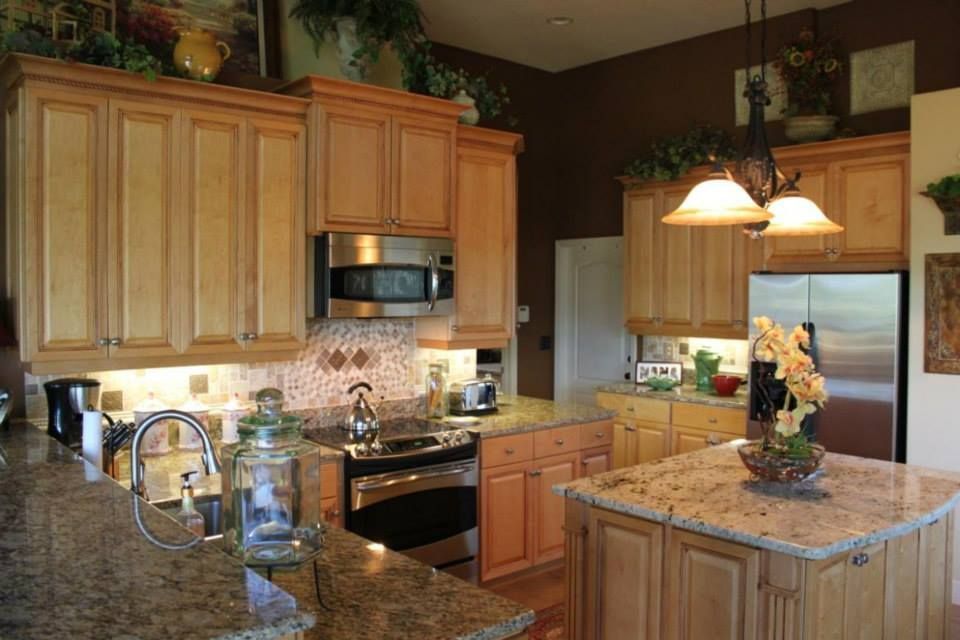 Kitchen with light wood cabinets, granite countertops, and stainless steel appliances.