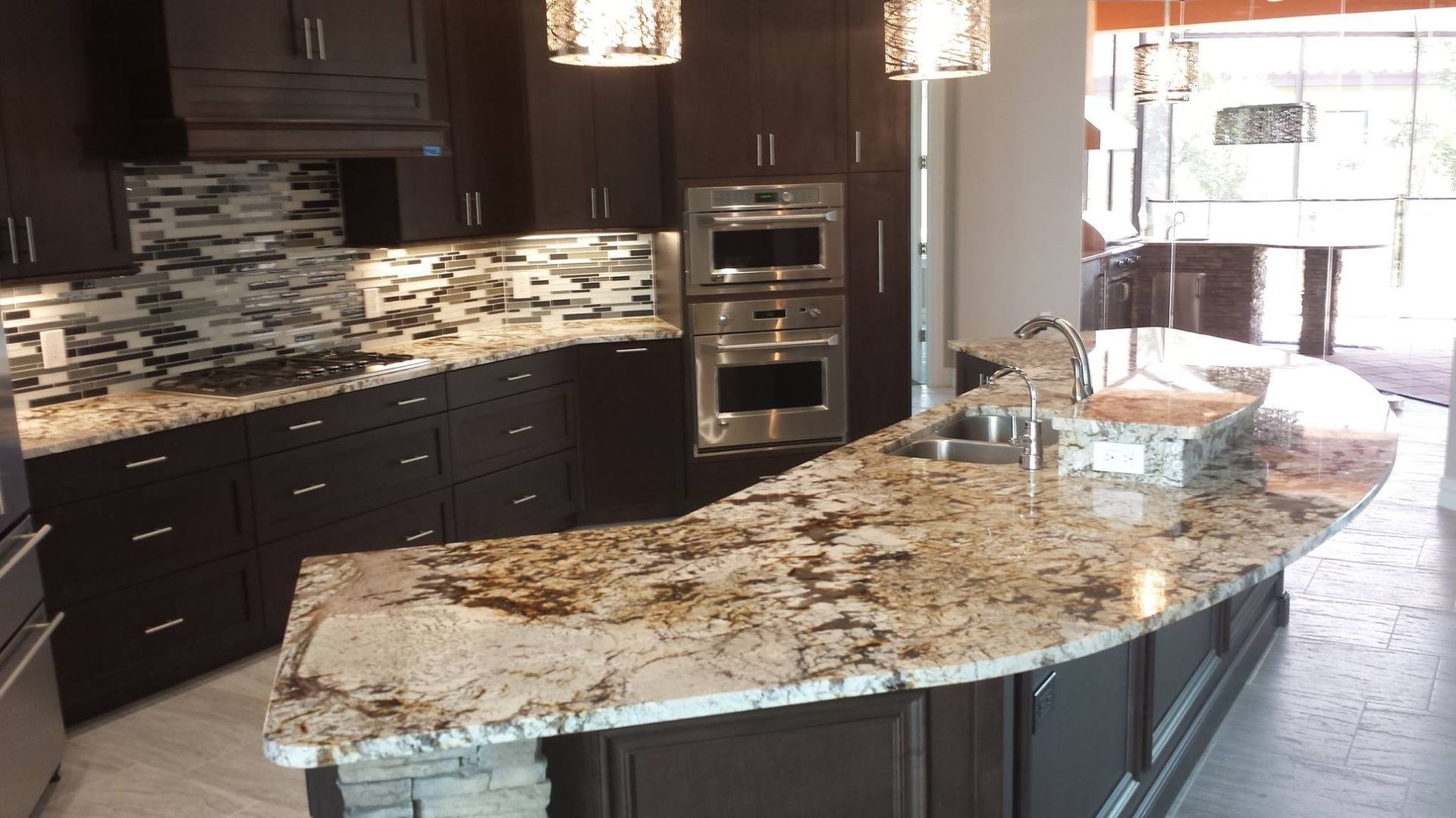 Modern kitchen with dark cabinetry, light-colored countertops, and stainless steel appliances.
