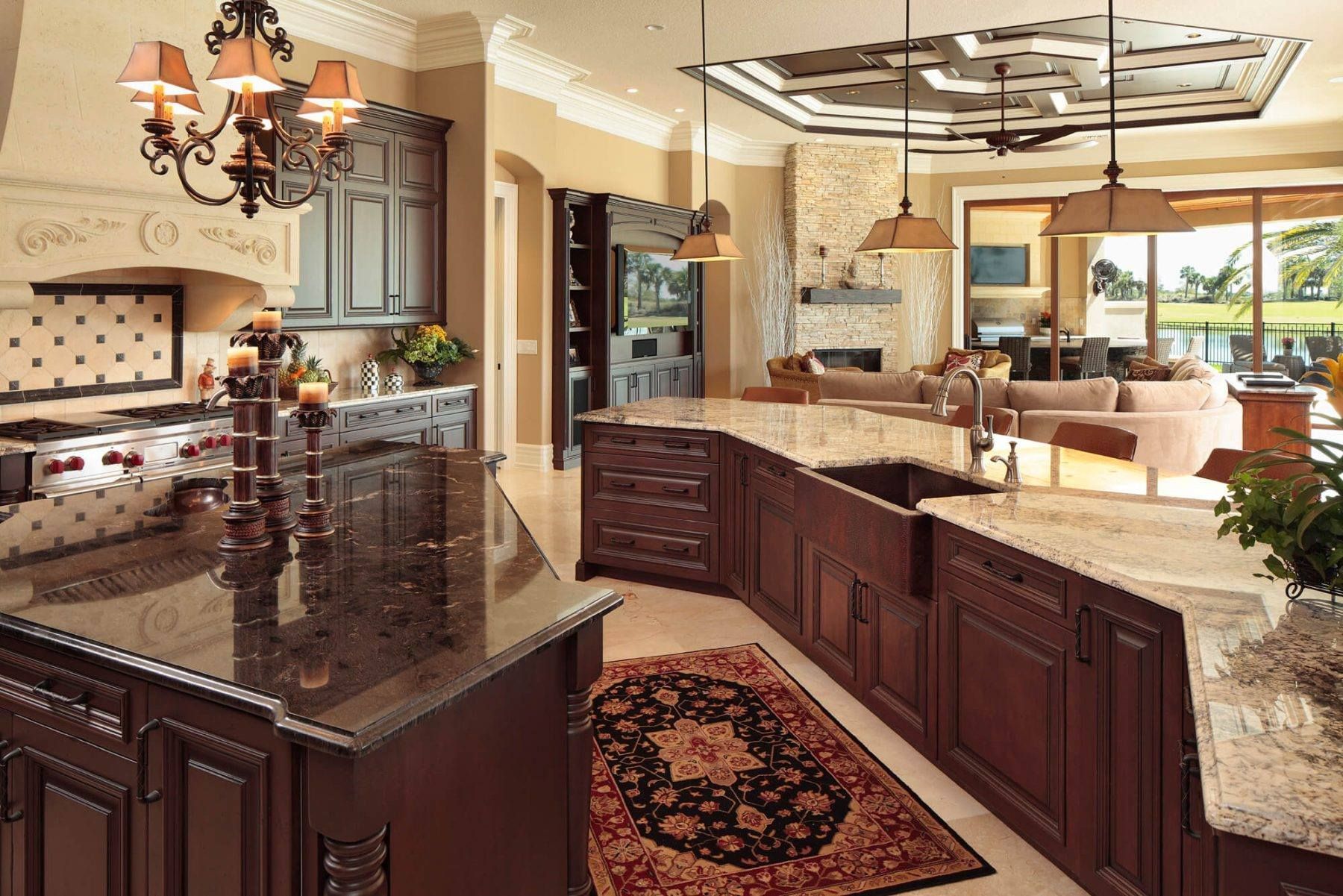 Luxurious kitchen with dark wood cabinetry, granite countertops, and a chandelier.