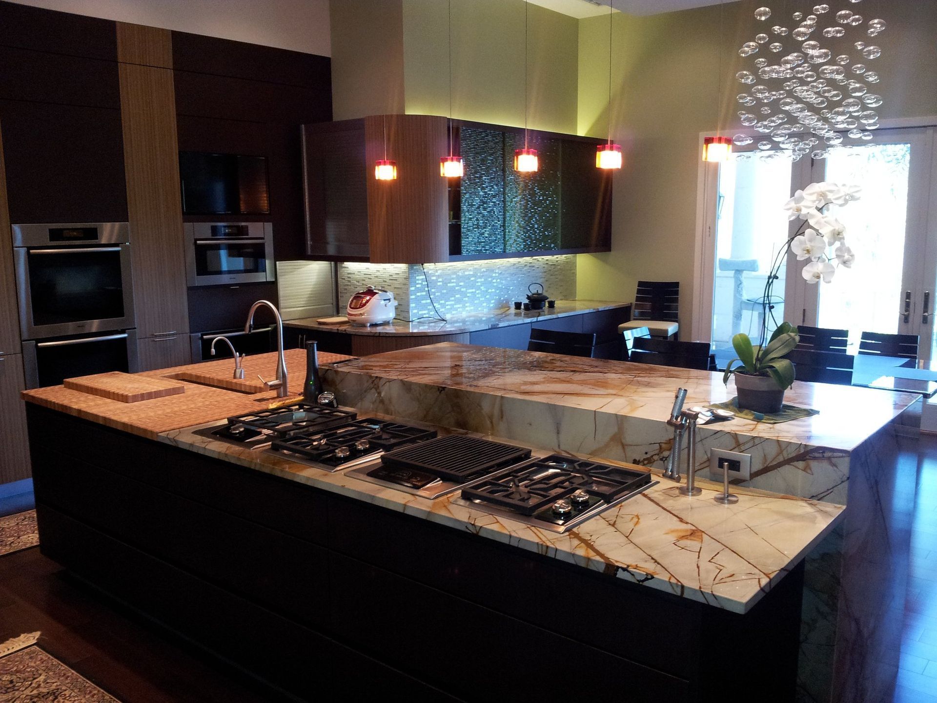 Modern kitchen with granite countertops, stovetop island, and dark wood cabinetry.