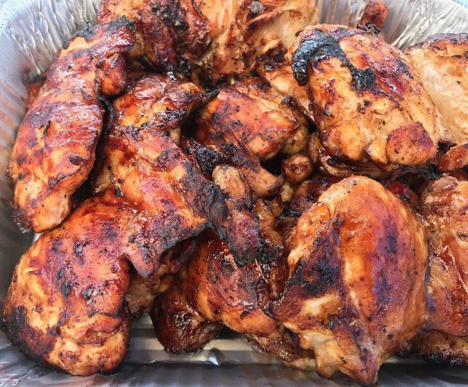 Tray of grilled barbecue chicken wings with charred, glossy skin