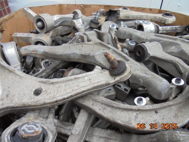 Pile of used car suspension control arms in a cardboard box
