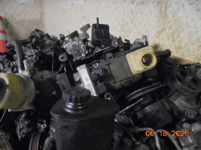 Heap of black and gray automotive parts in a cluttered setting