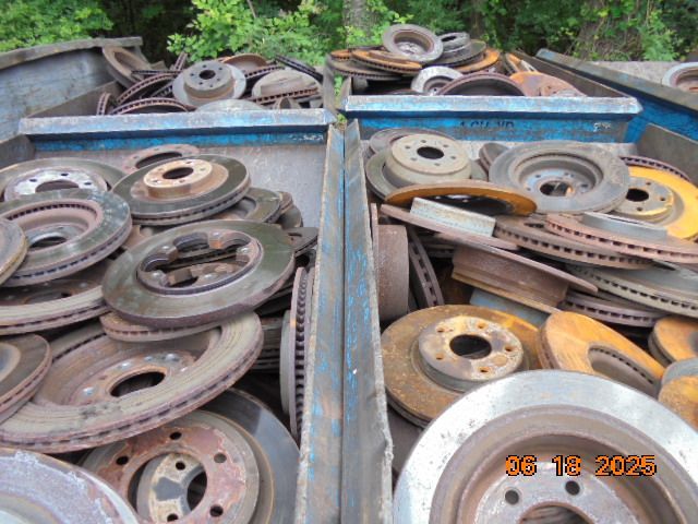Rusty car brake rotors piled in a metal bin