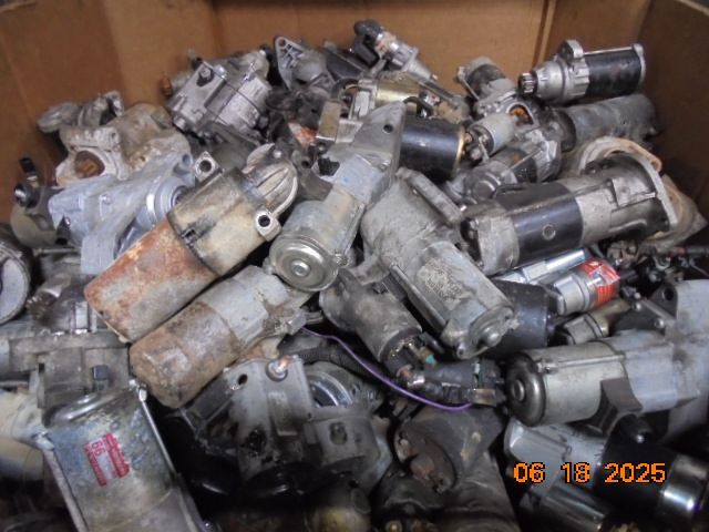 Pile of old car starters in a cardboard box