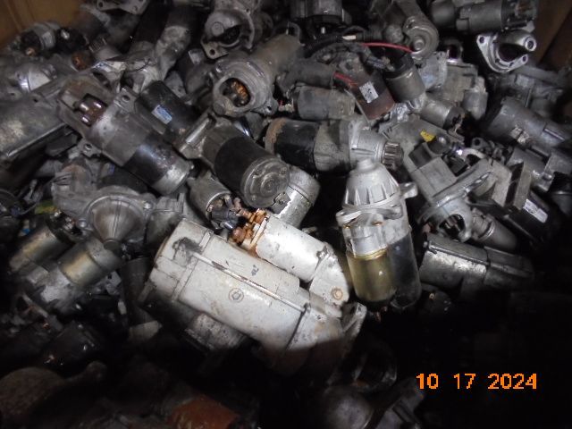 Pile of used automotive starters in a bin