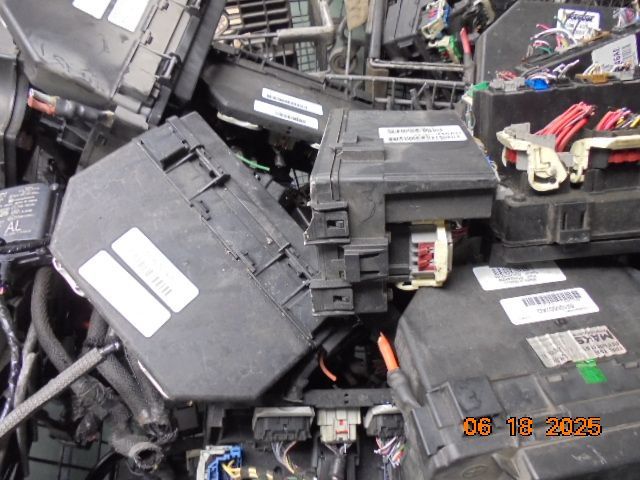 Pile of black automotive electrical components, fuse boxes, and modules