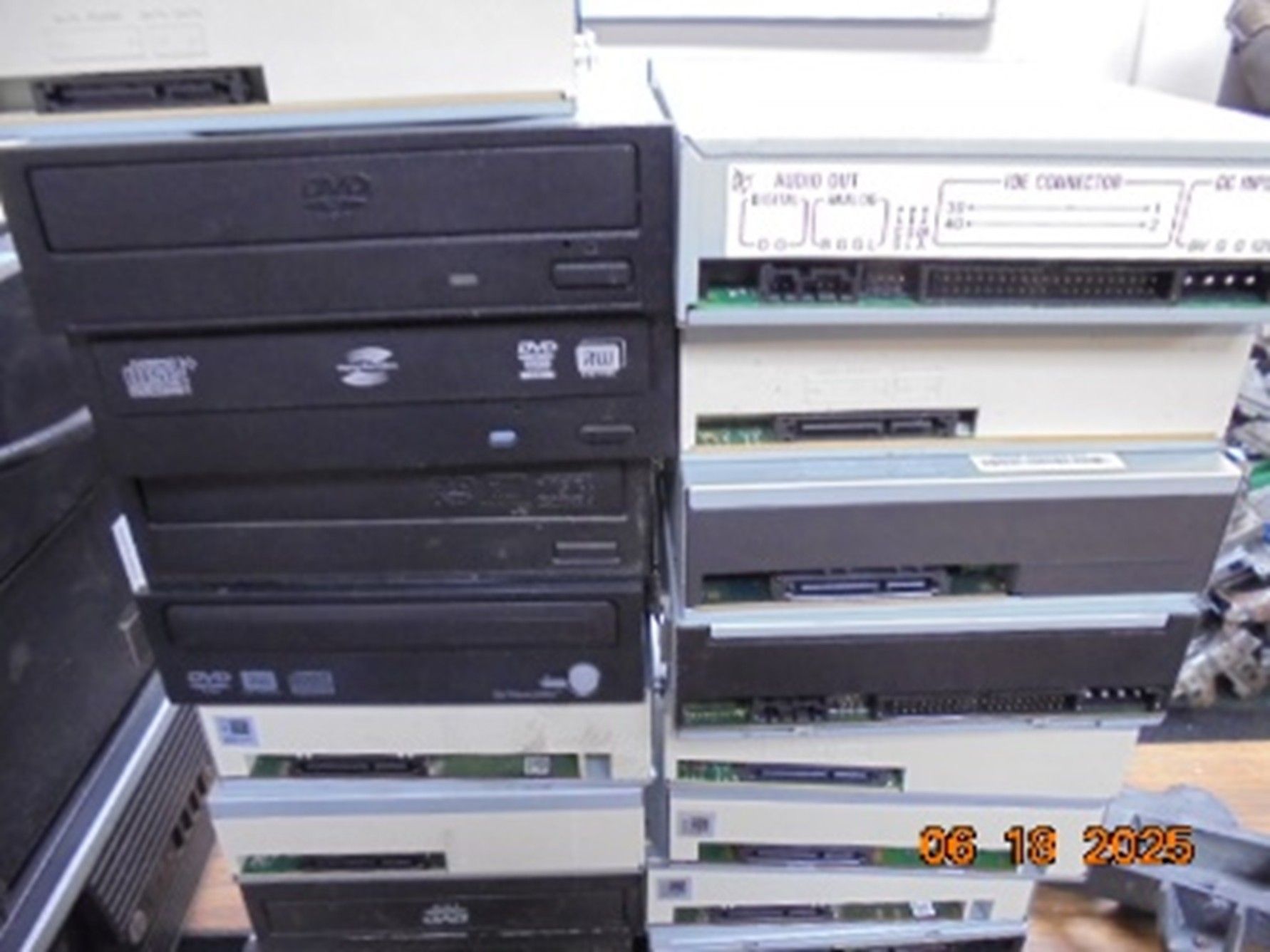 A stack of computer optical disc drives in black and off-white, viewed from the front and rear panels.