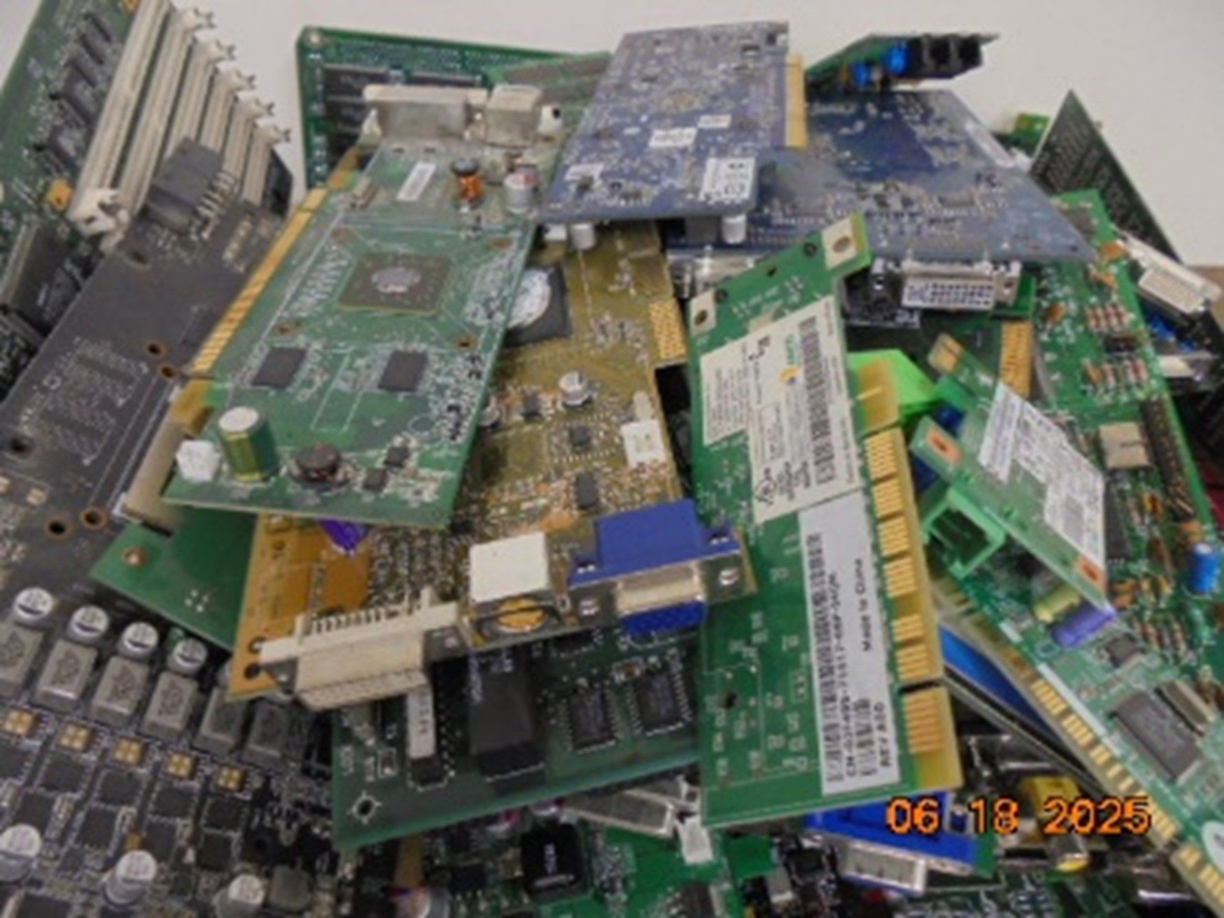 A pile of assorted, discarded electronic computer circuit boards and components with varying colors and textures.
