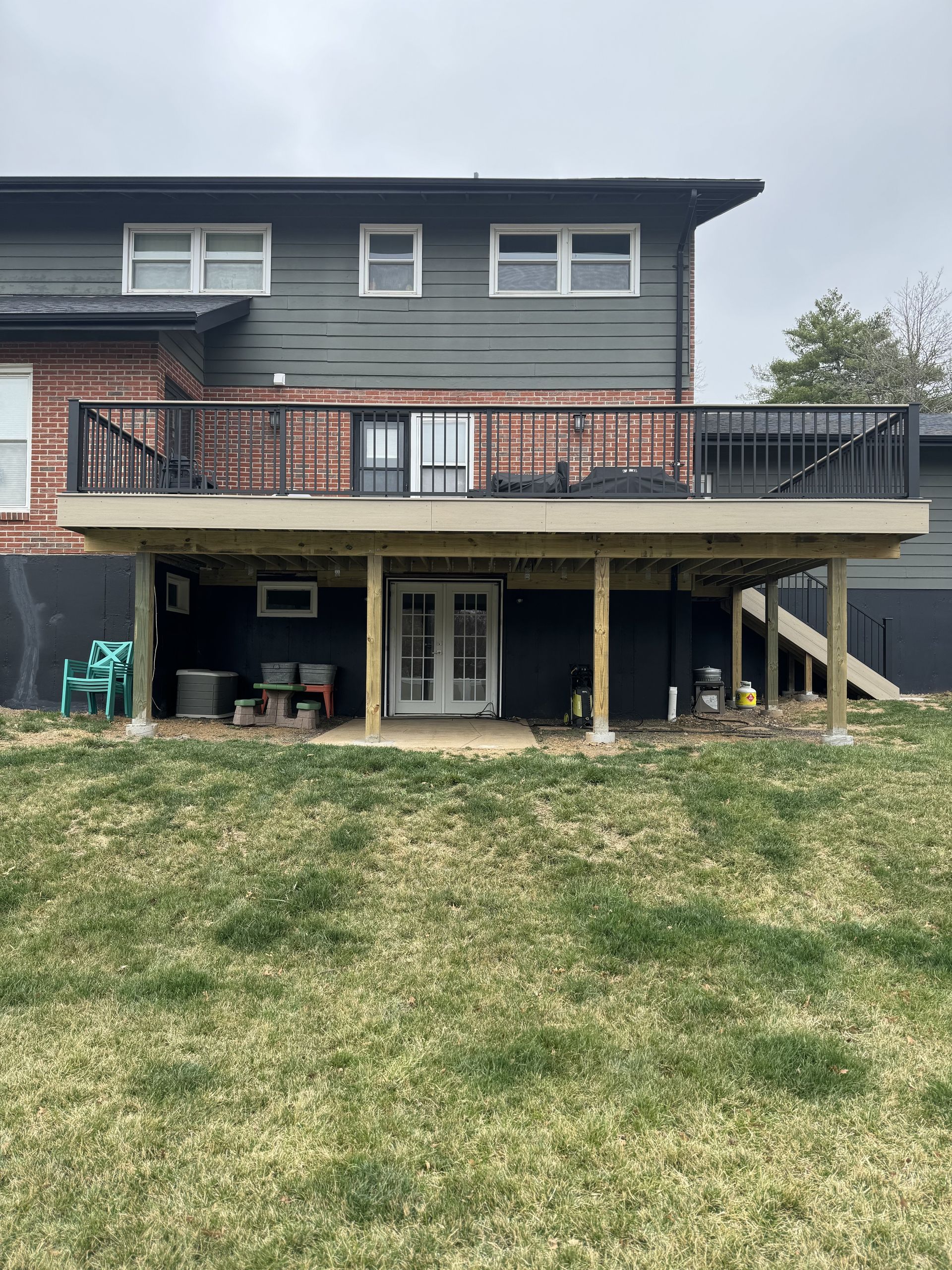 A large deck is sitting in the backyard of a house.