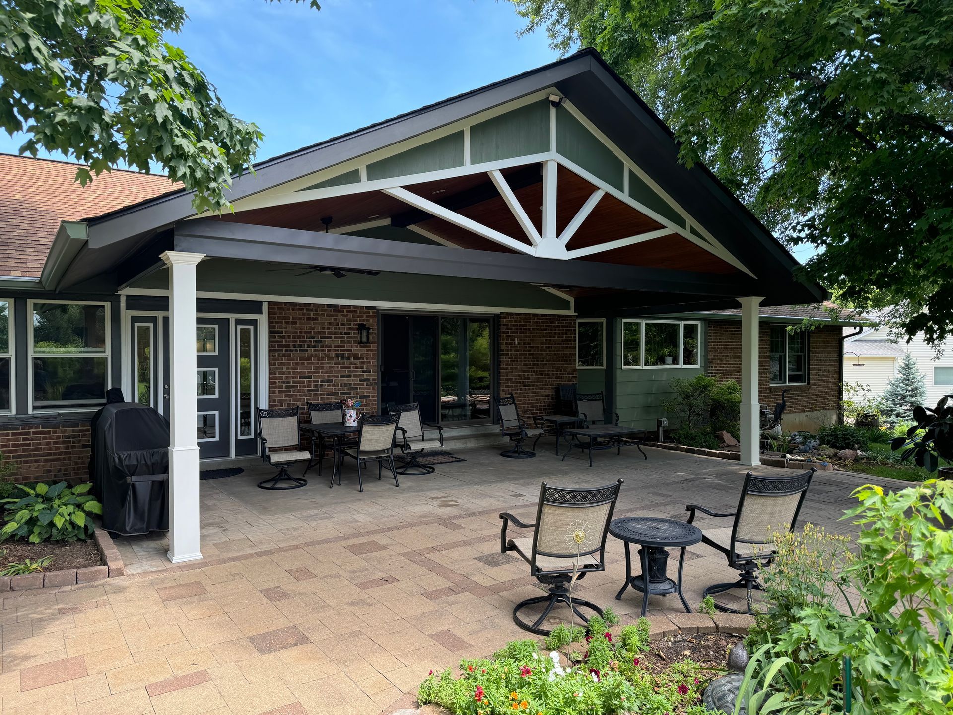 A house with a covered patio with chairs and tables