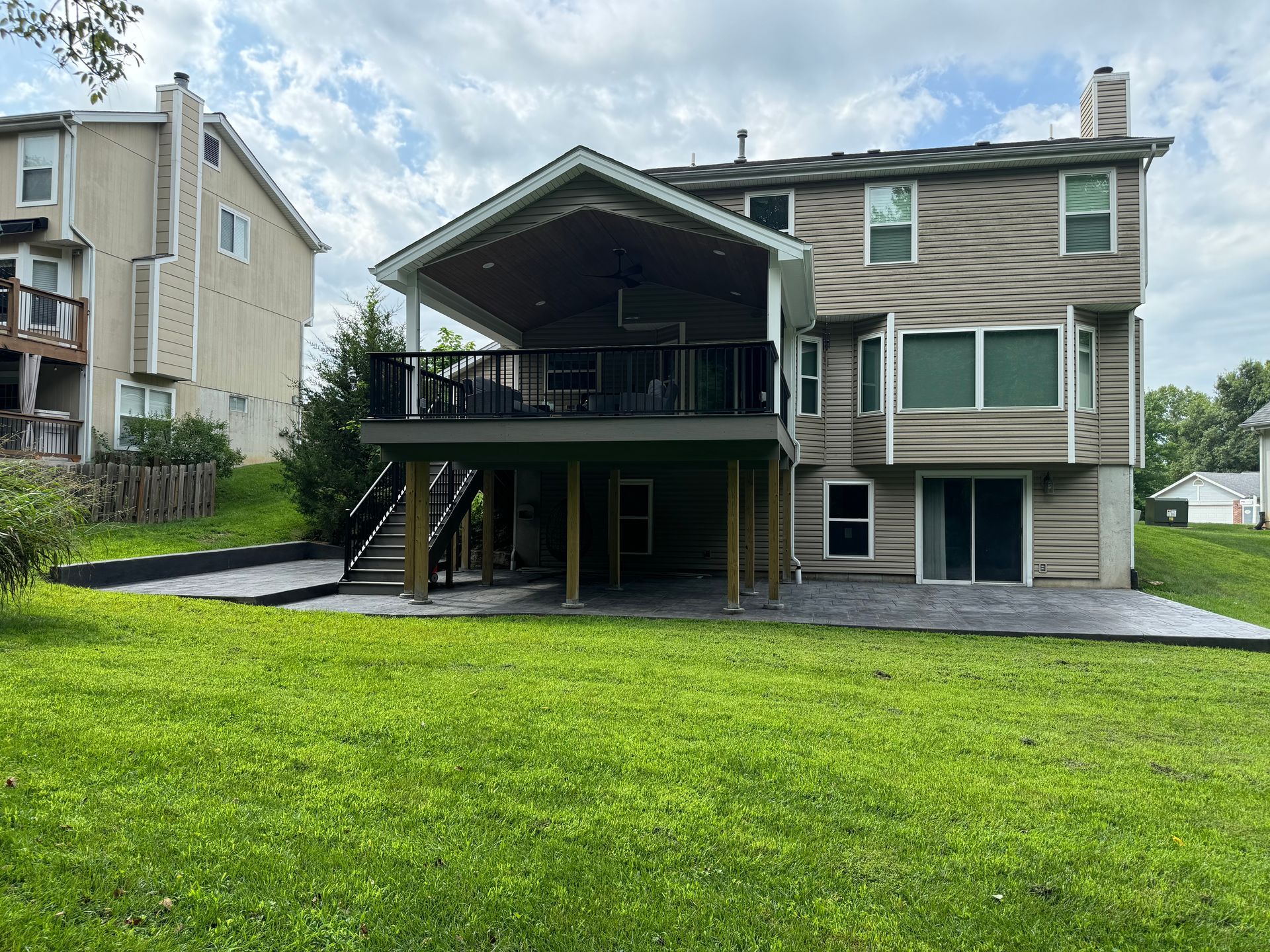 The back of a house with a large deck and patio.