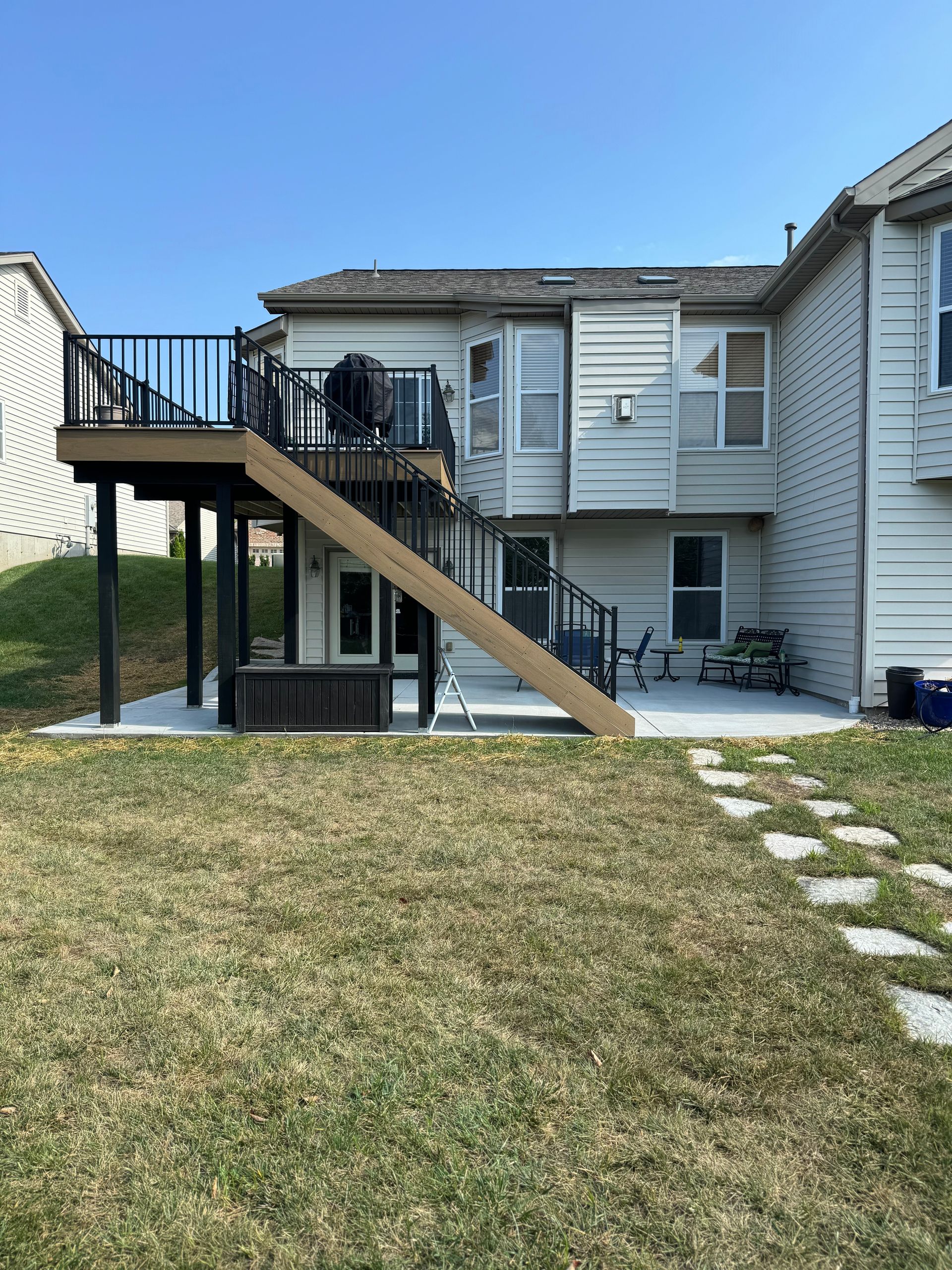 A house with a deck and stairs in the backyard