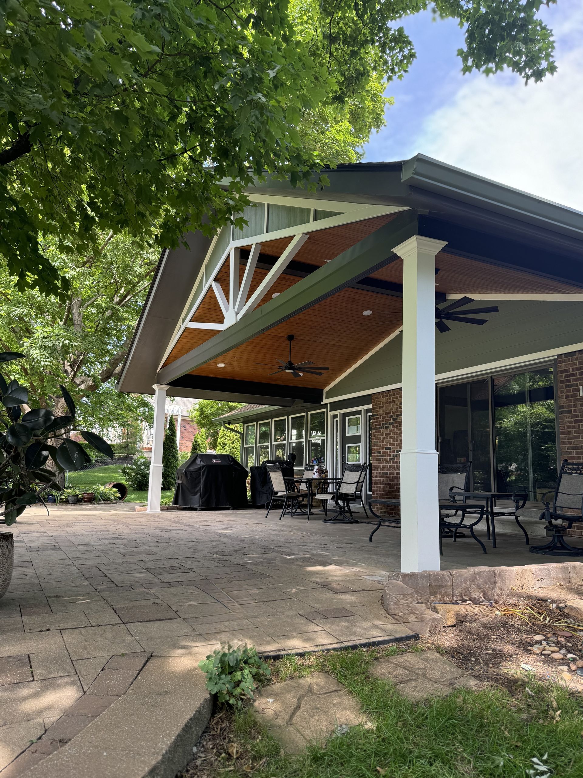 A large covered patio area with tables and chairs under a roof.