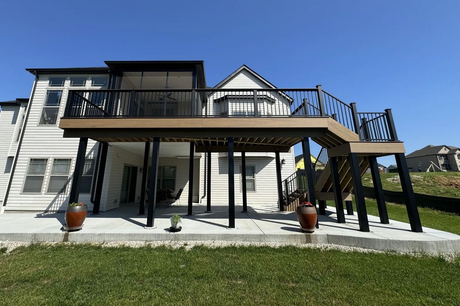 The back of a house with a large deck and stairs.