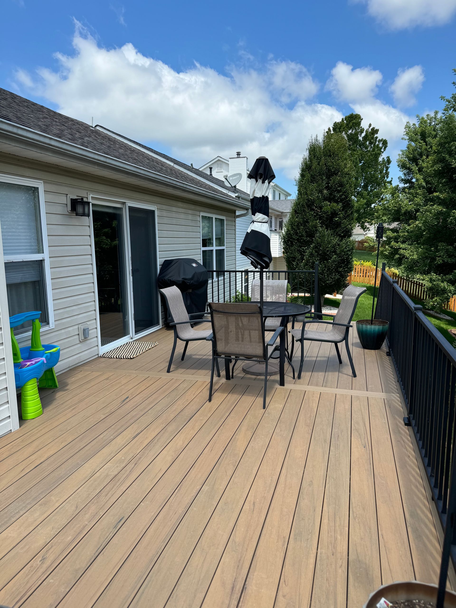 There is a deck with a table and chairs on it.