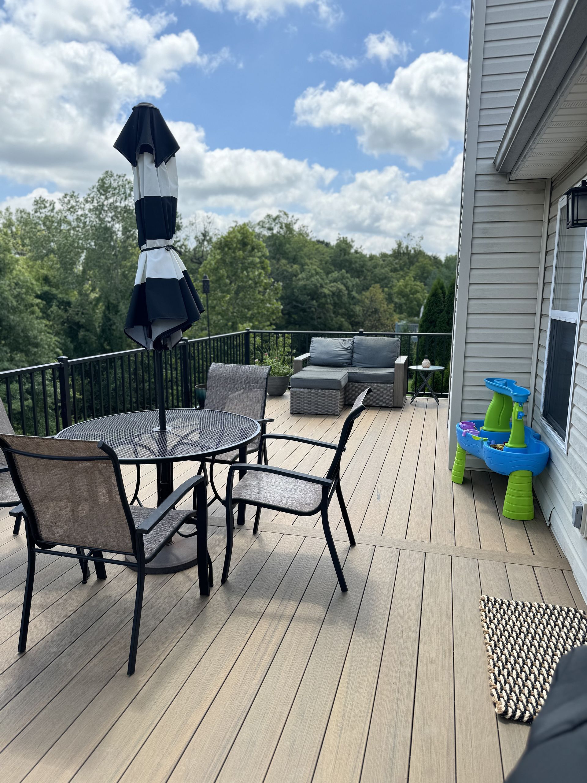 A deck with a table and chairs and an umbrella
