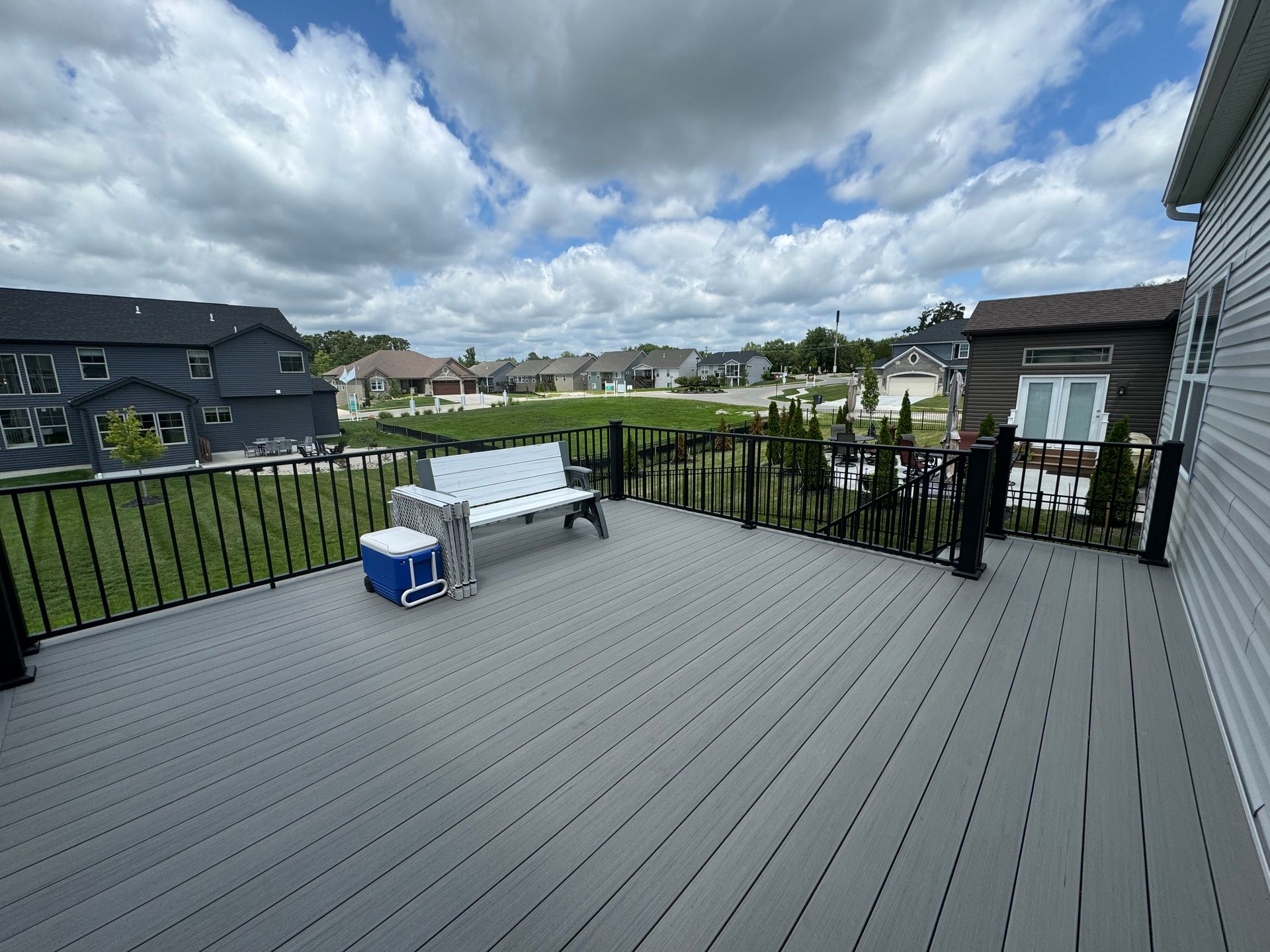 There is a deck with a bench and a cooler on it.