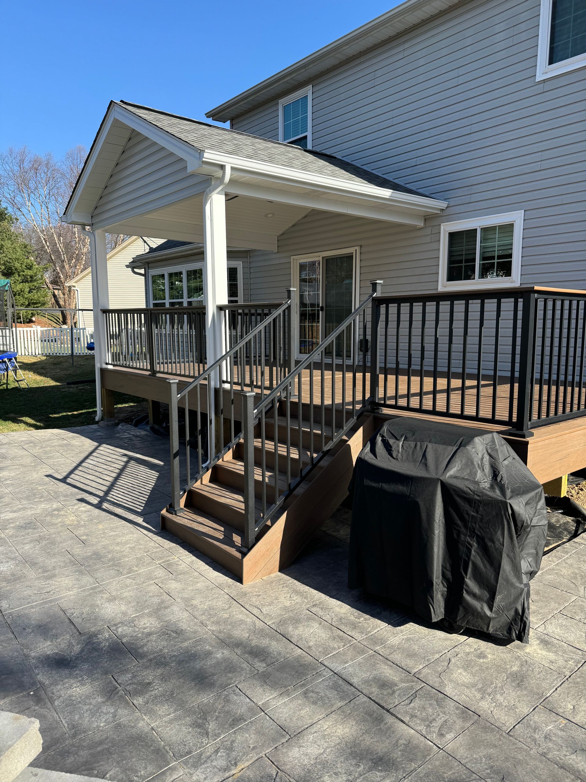 A house with a deck and stairs in front of it.