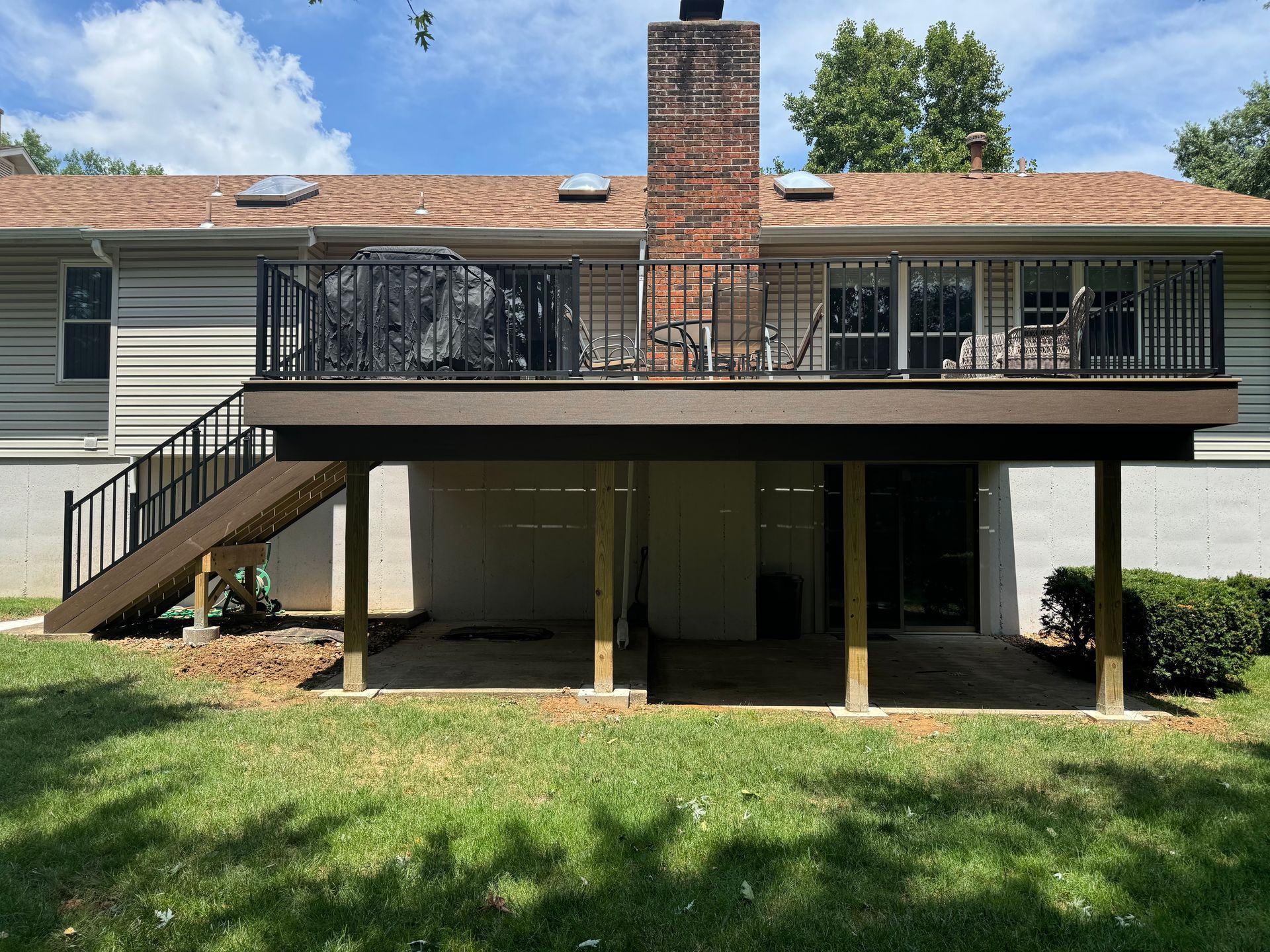 The back of a house with a large deck and stairs.