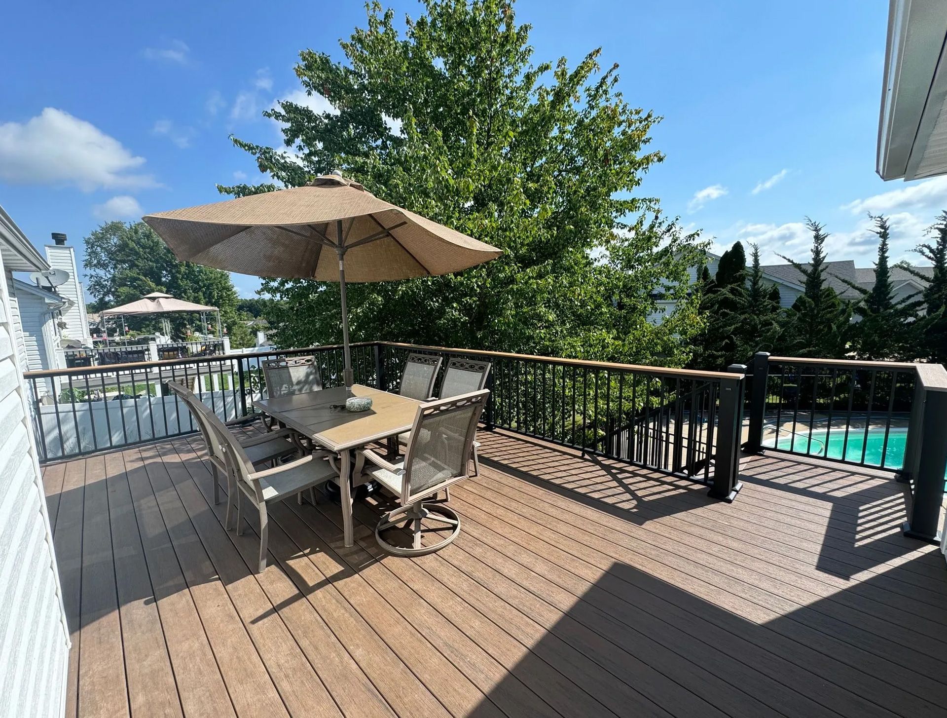 A deck with a table and chairs and an umbrella