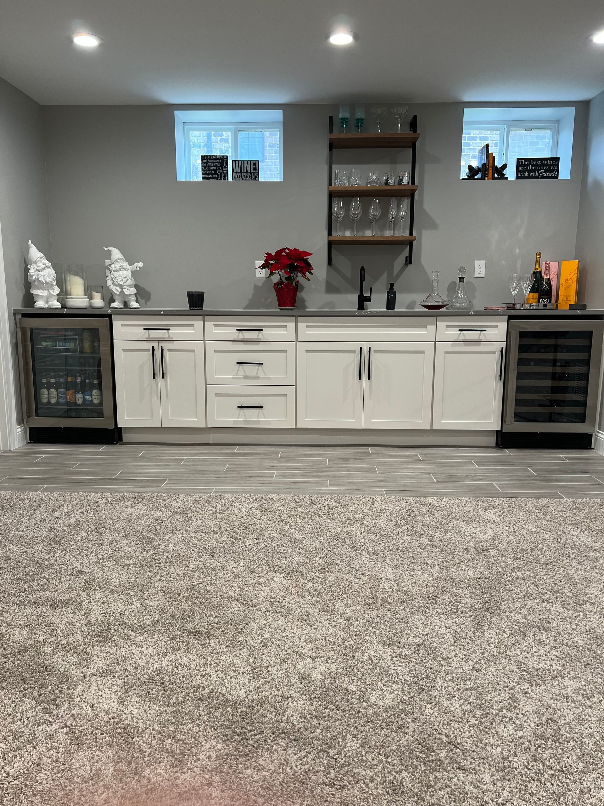 A kitchen with white cabinets, a refrigerator and a sink.