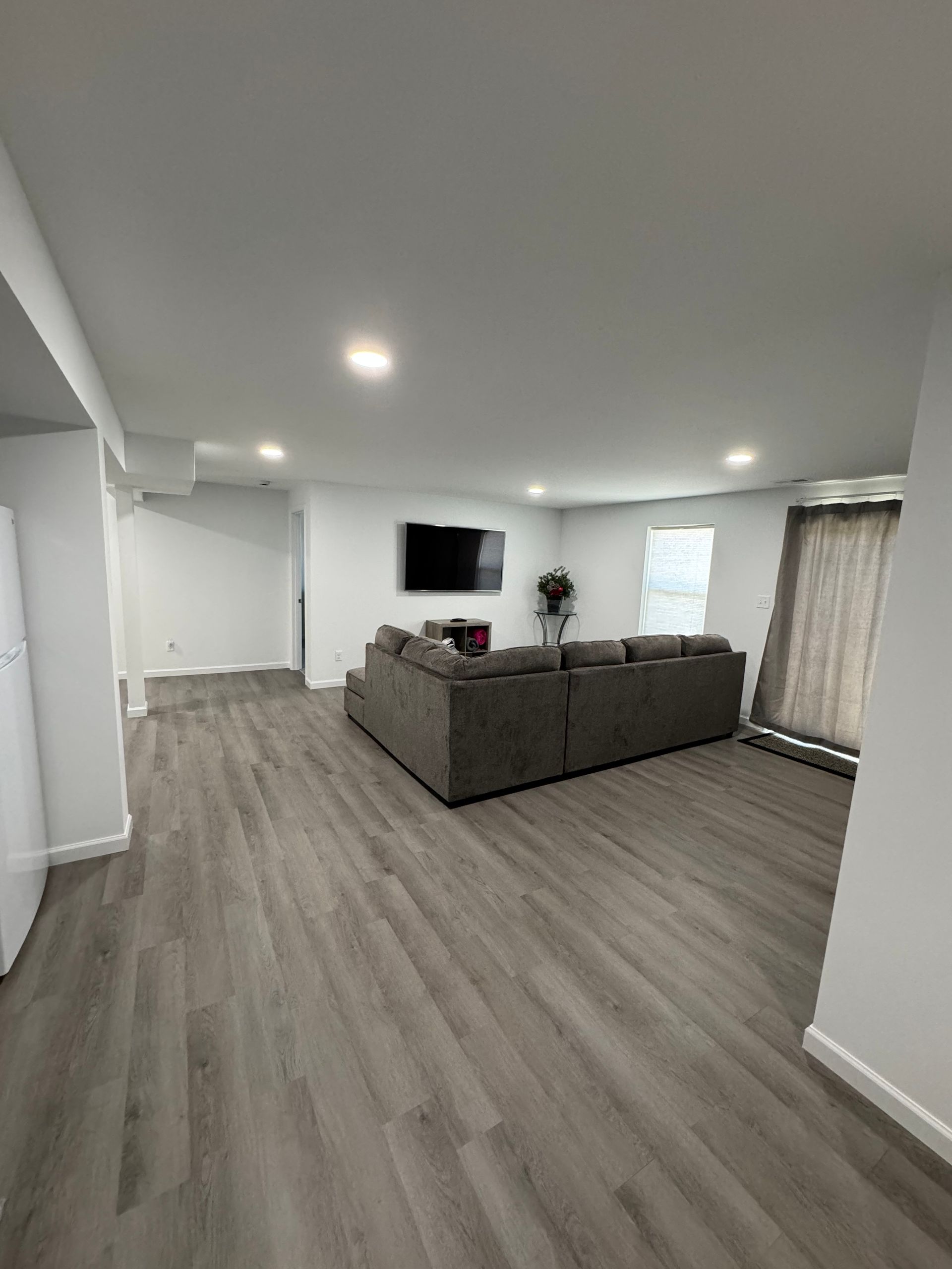 A living room with a large couch and a flat screen tv.