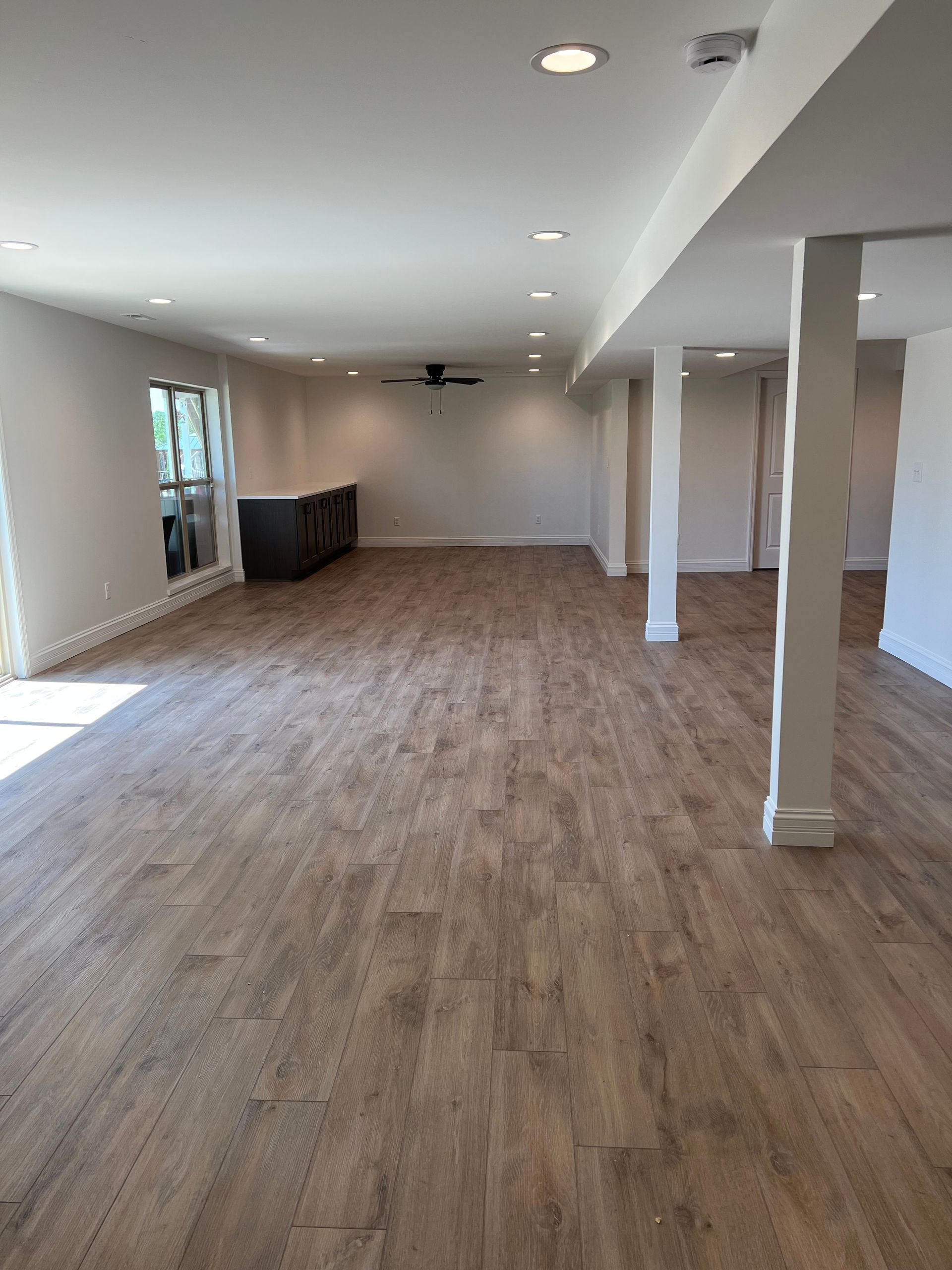 A large empty room with hardwood floors and white walls.