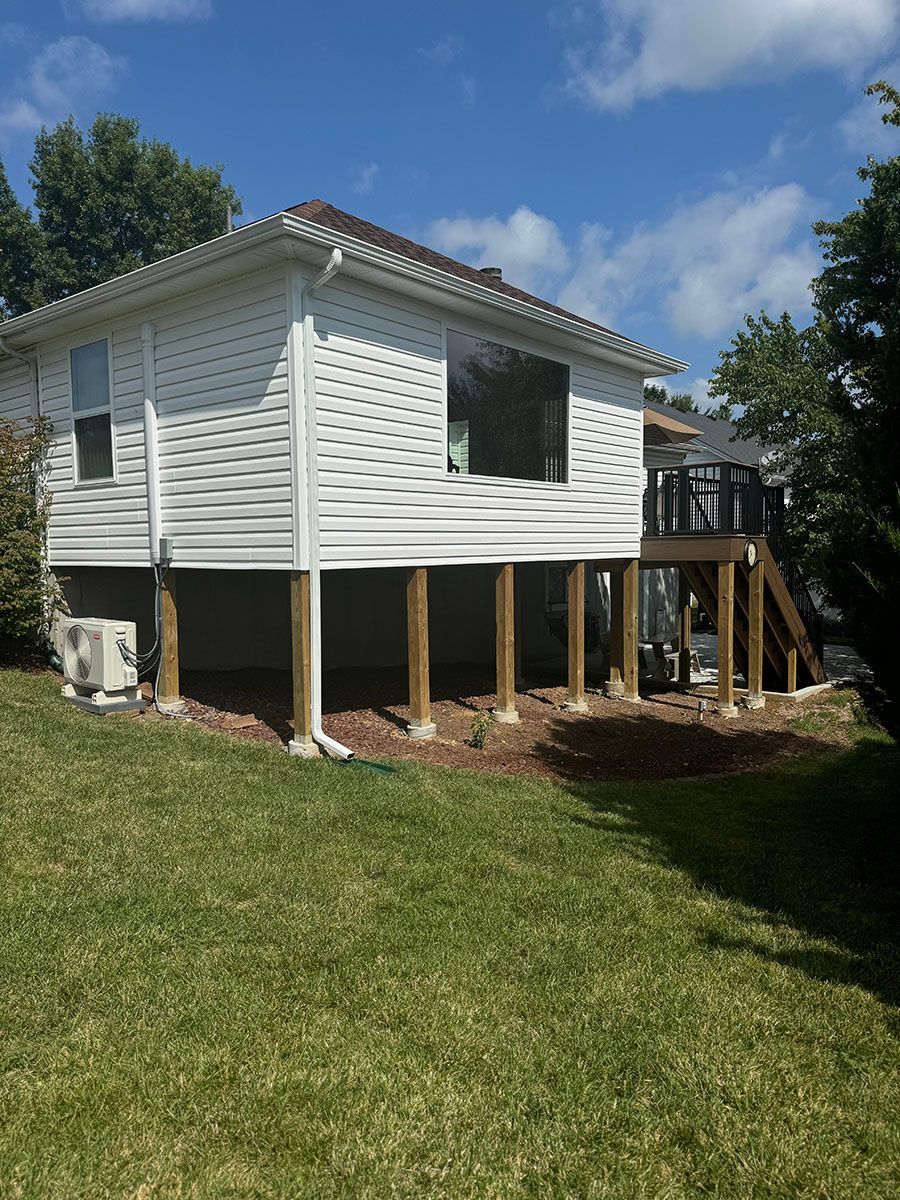 A white house with a covered deck in the backyard