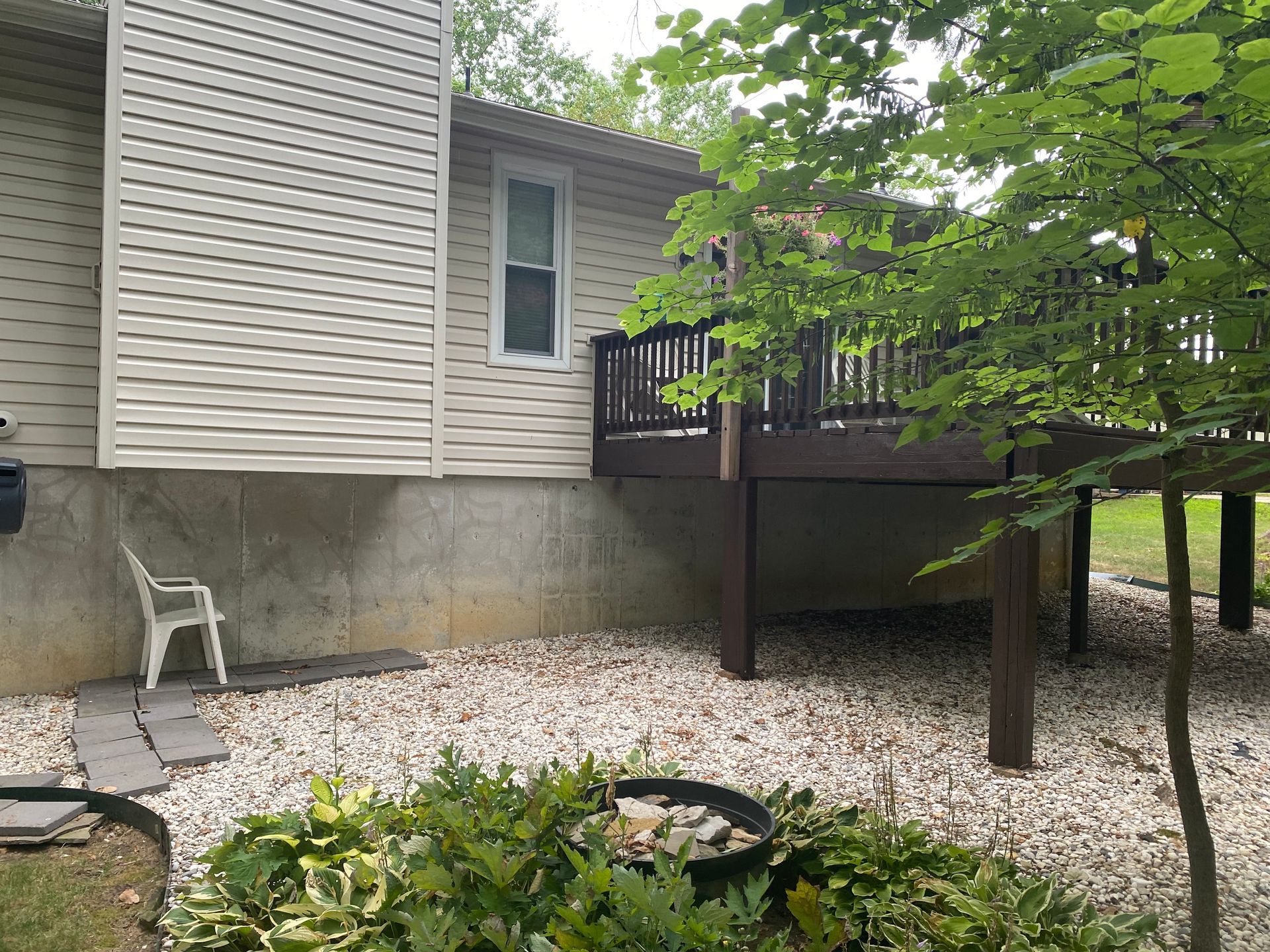 A house with a deck and a chair in front of it