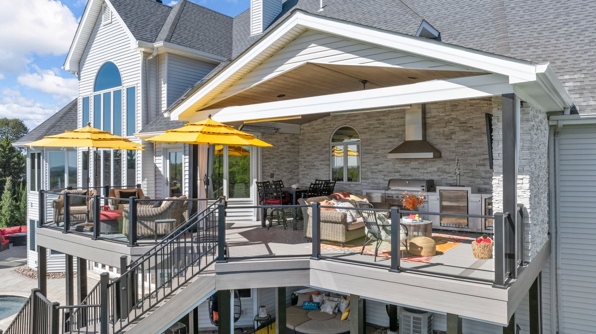 A large house with a large deck and umbrellas