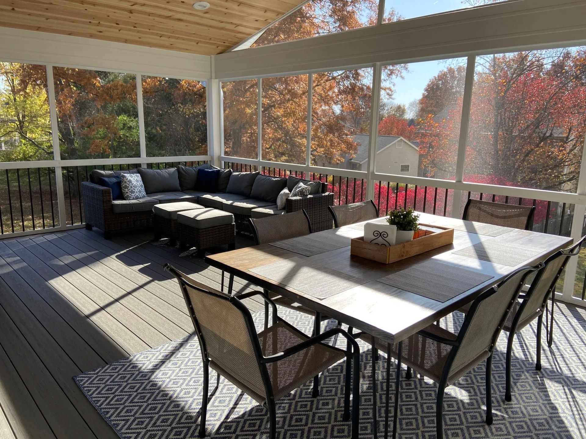 A screened in porch with a table and chairs and a couch.