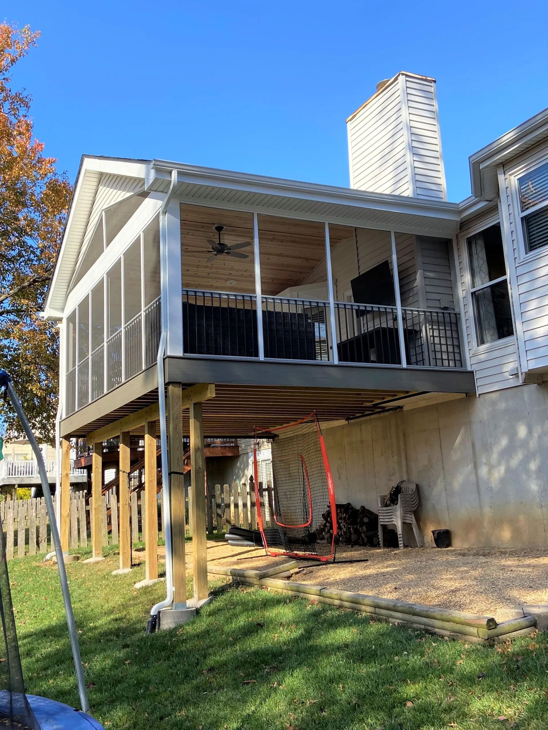 A screened in porch is being built on top of a house.