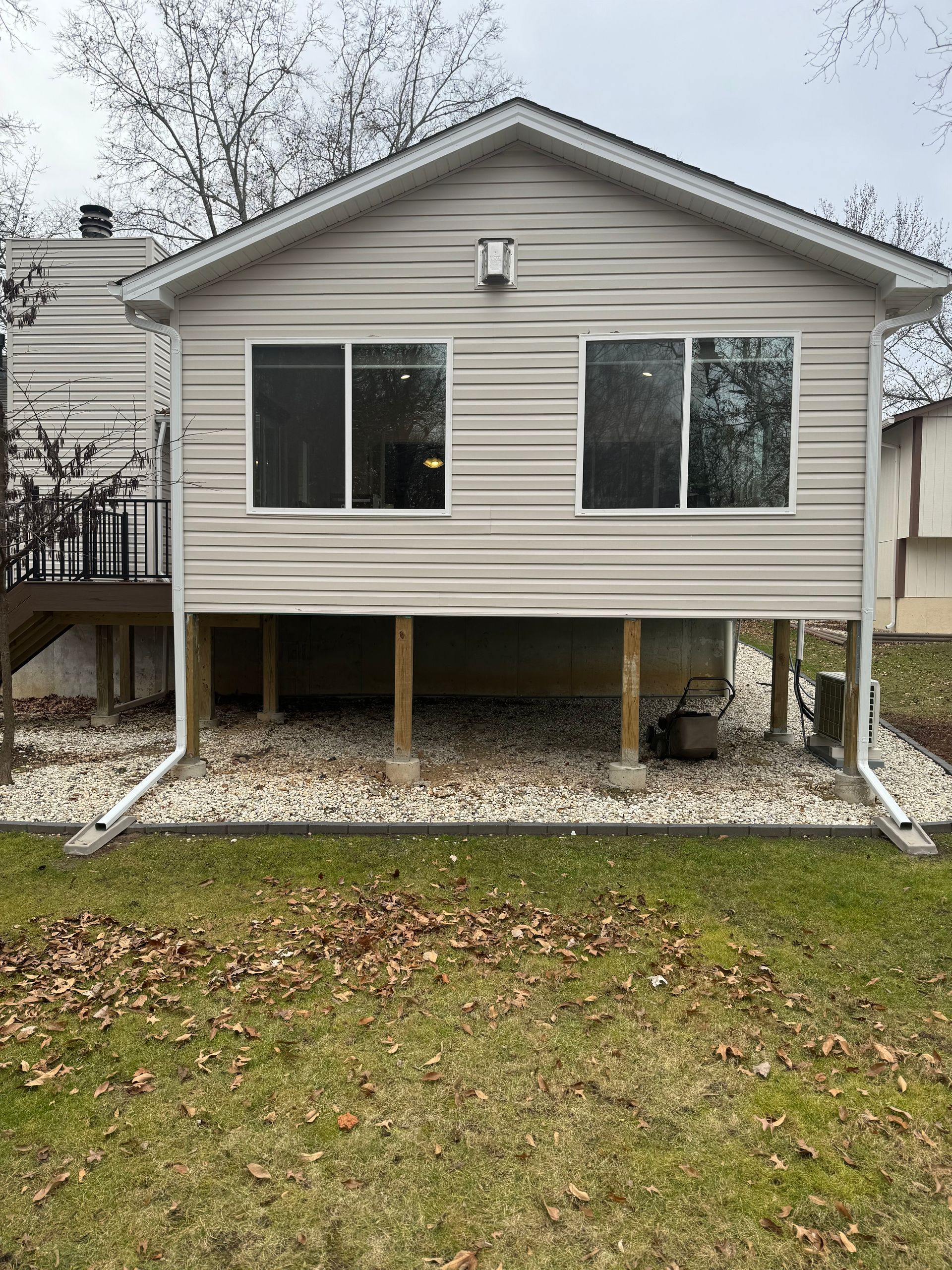 The back of a house with a lot of windows and a deck.