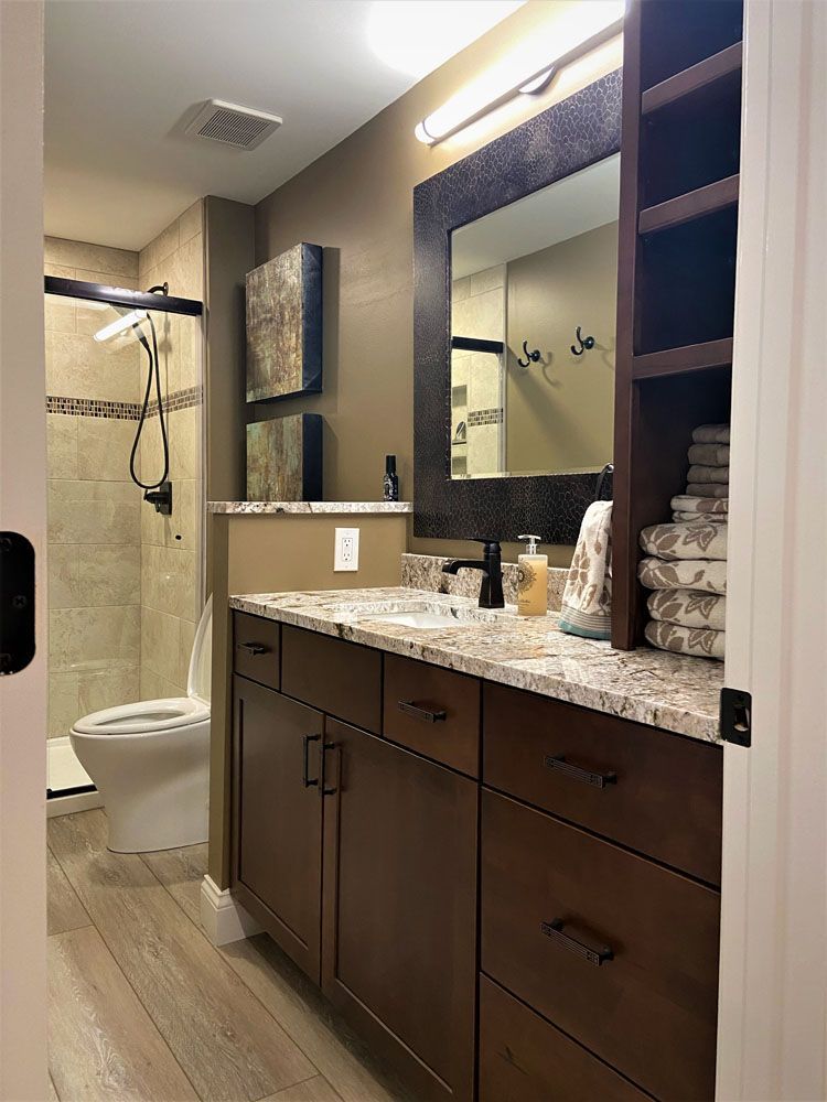 A bathroom with a toilet, sink, and big mirror