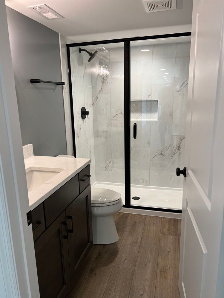 A bathroom with glass sliding shower door
