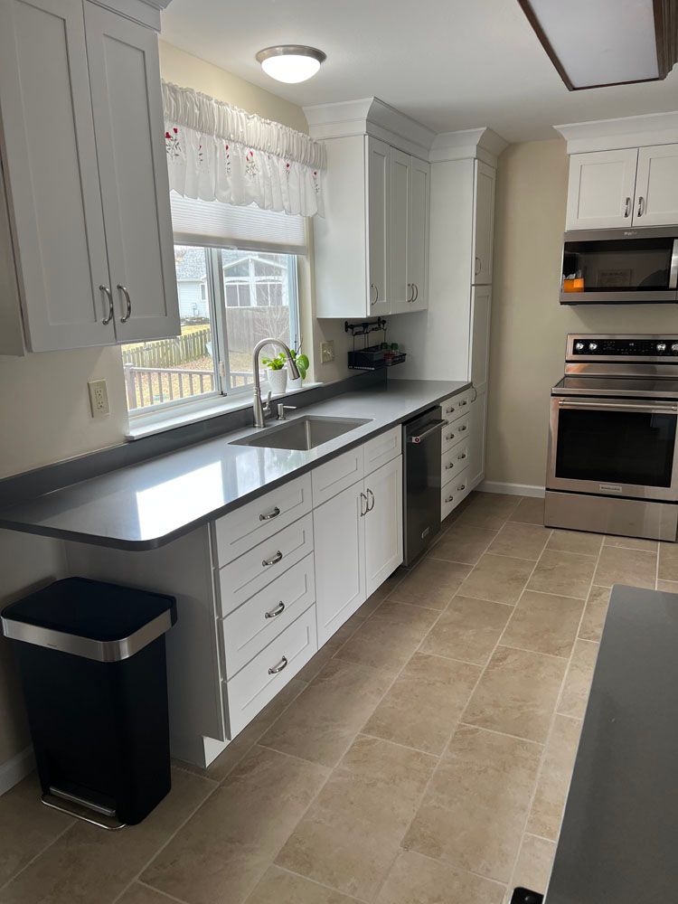 A kitchen with white cabinets and stainless steel appliances