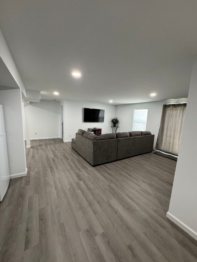 A living room with a large couch and a flat screen tv