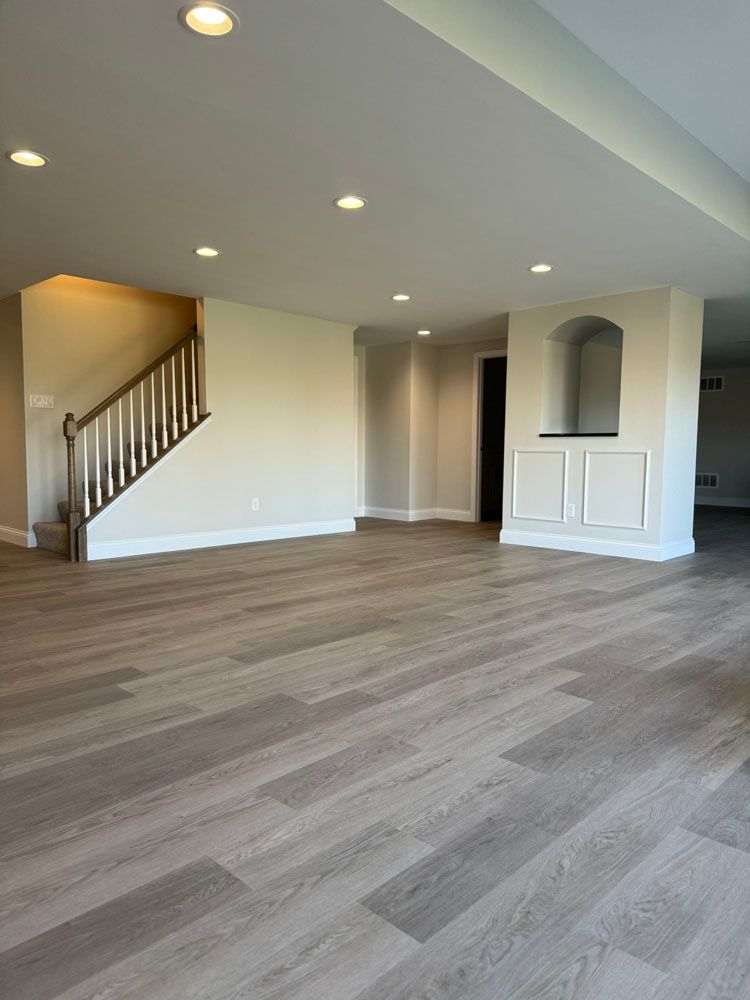An empty living room with hardwood floors and stairs