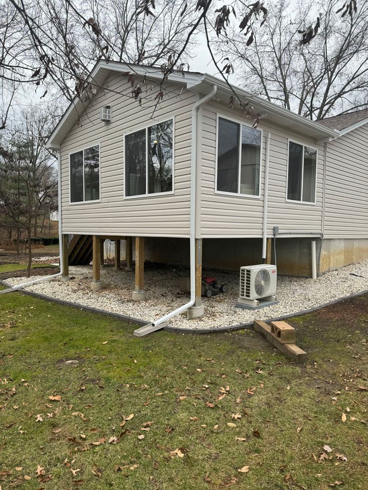 A mobile home is being built on stilts and has a lot of windows