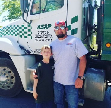 Two people standing beside a white-and-green moving truck with company logo and checkered pattern