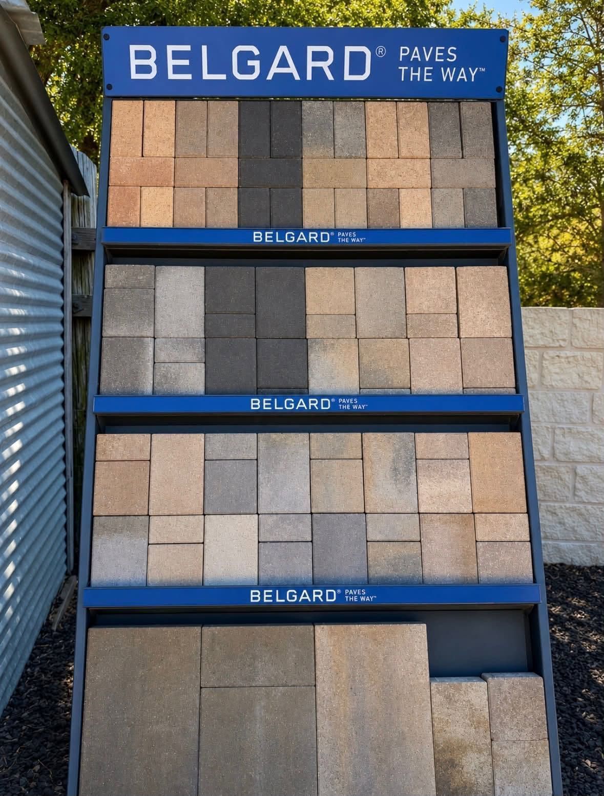 Belgard paving stone display rack with gray and tan paver samples on shelves