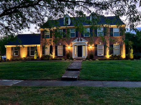 A large brick house is lit up at night