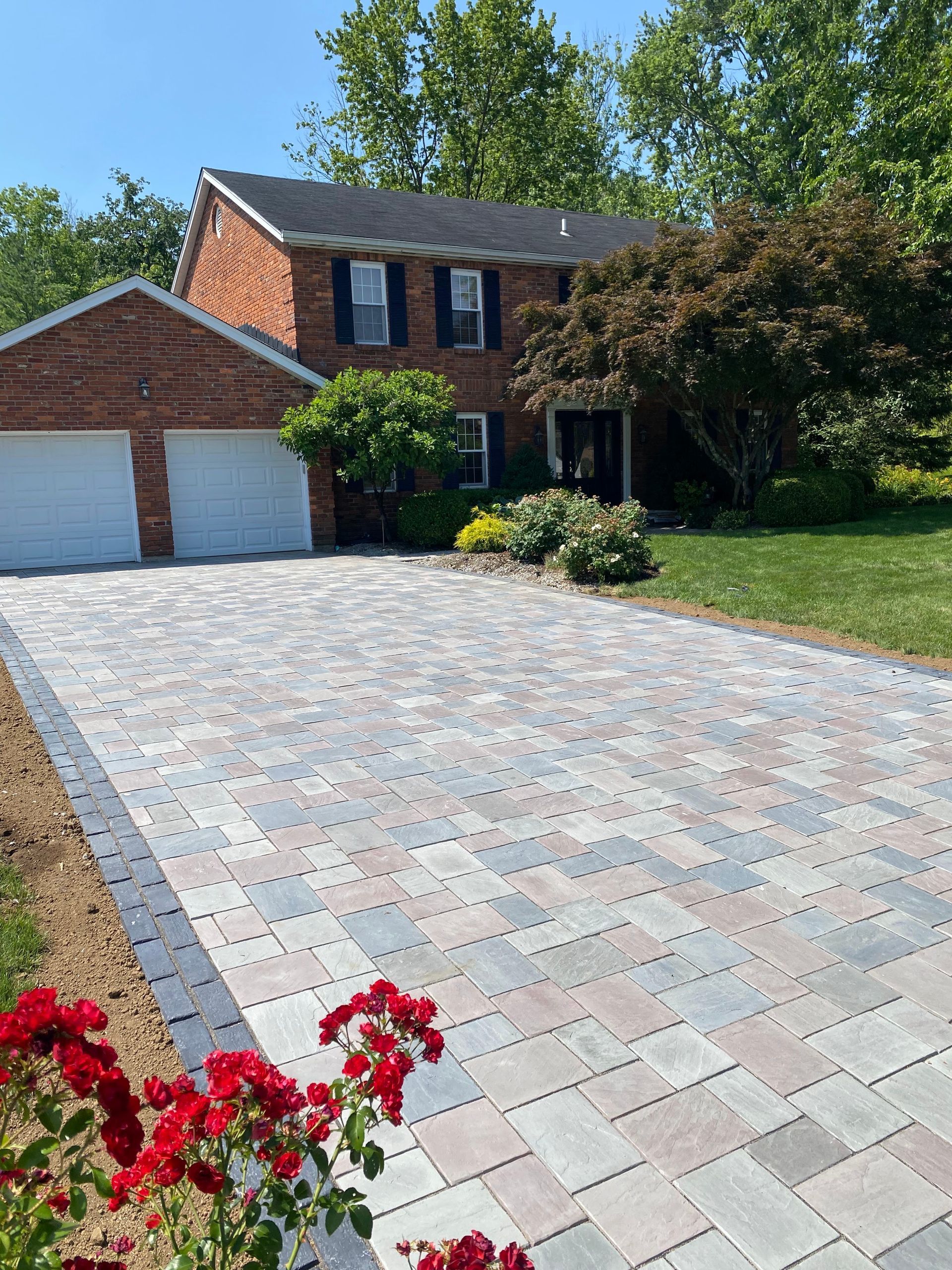 A brick house with a brick driveway in front of it