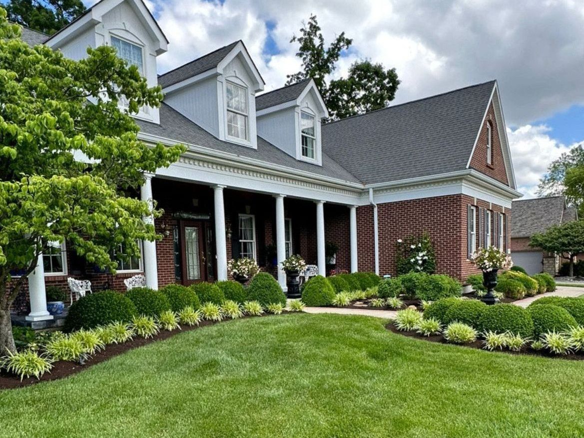 A large house with a lush green lawn in front of it.