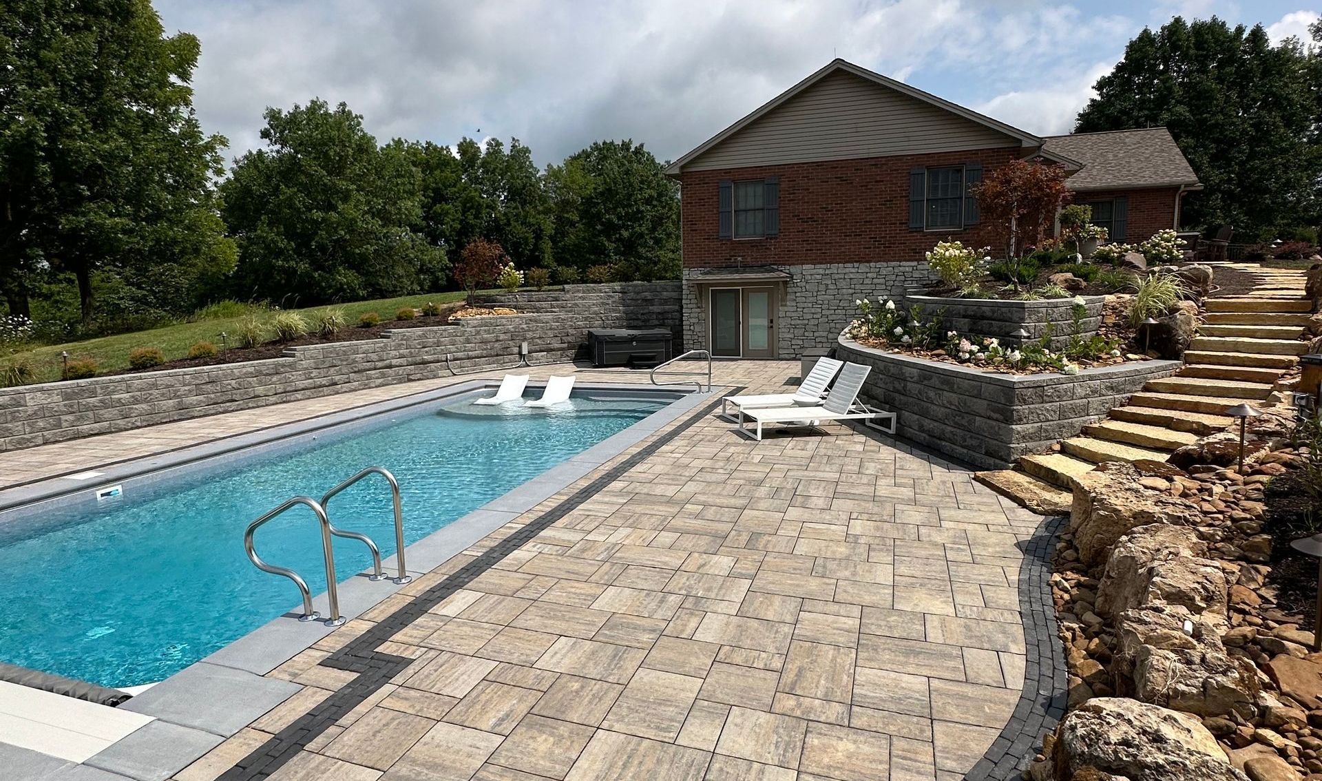 There is a large swimming pool in the backyard of a house.