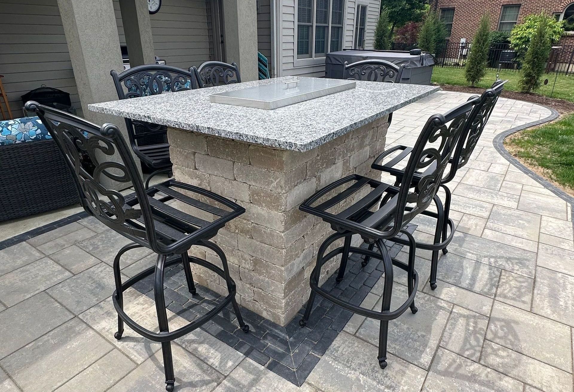 A patio with a table and chairs in front of a house.