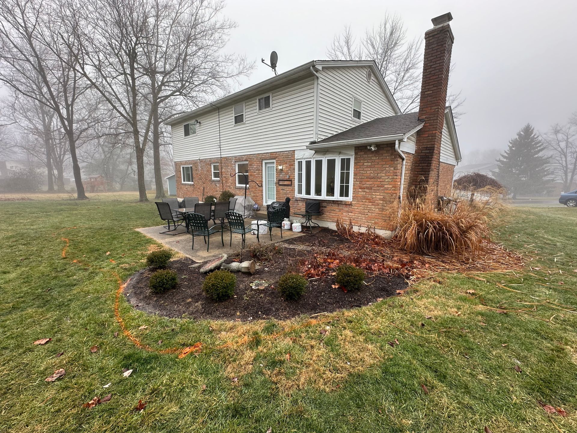 A house with a patio in front of it on a foggy day